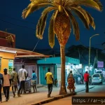 Home 19 가봉의 주요 범죄 유형과 예방 - A bustling urban street scene in Libreville, Gabon at night, showing diverse pedestrians walking car...